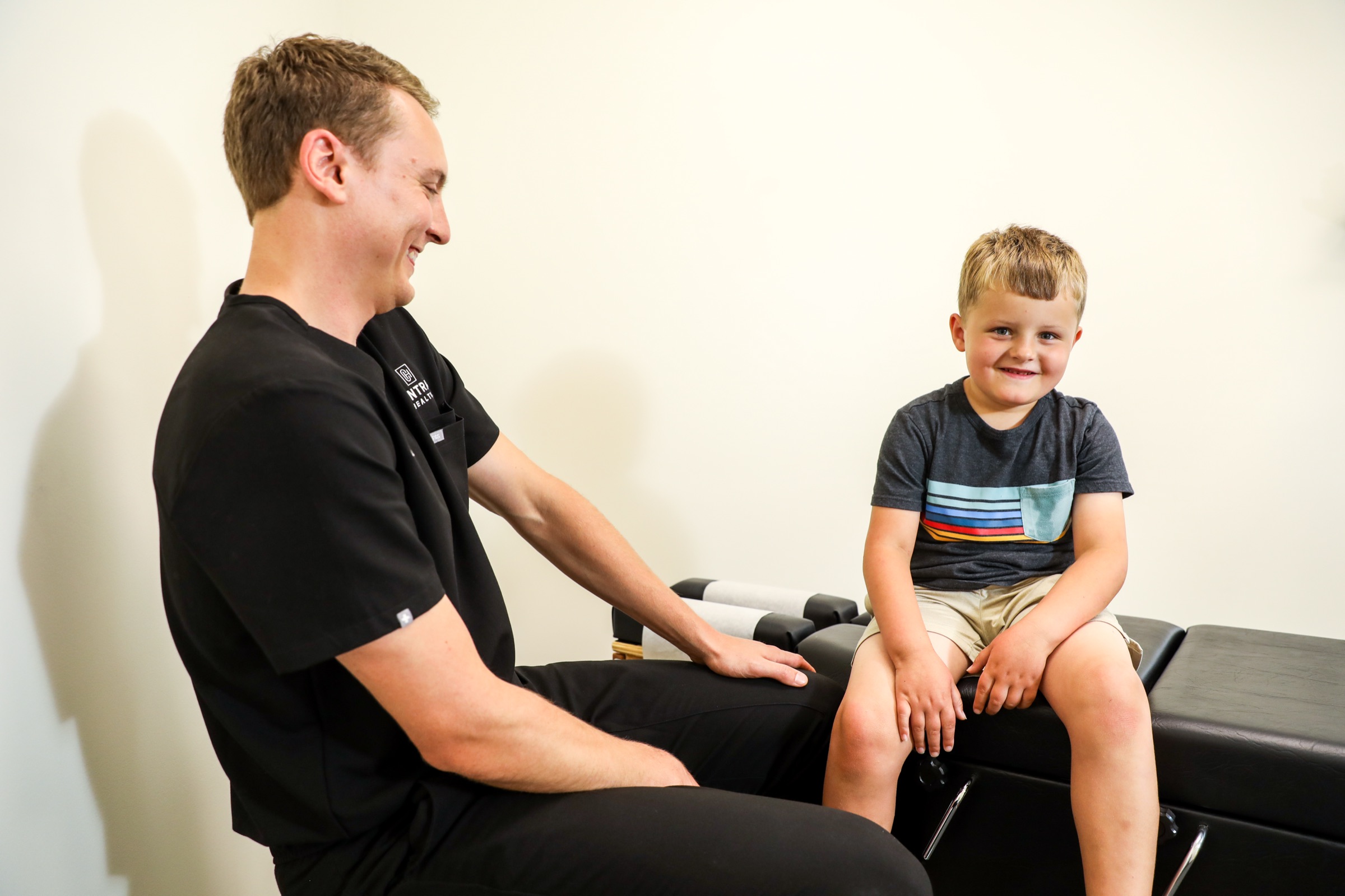 Dr. Emmerich with a young boy on the adjusting table at Central Health