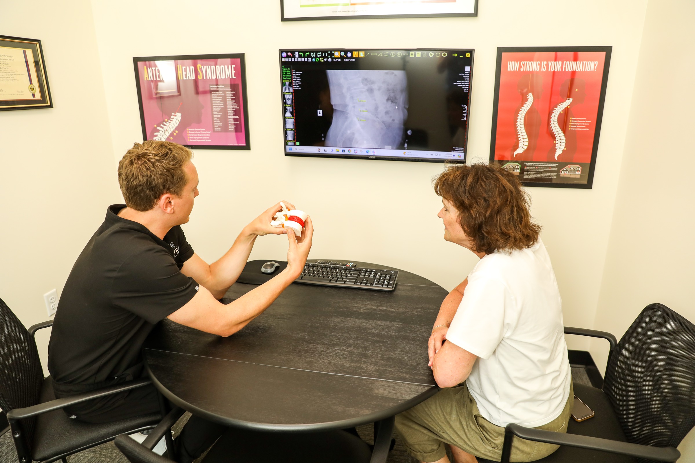 Dr. Emmerich and a patient at the consult table with an X-ray on the screen